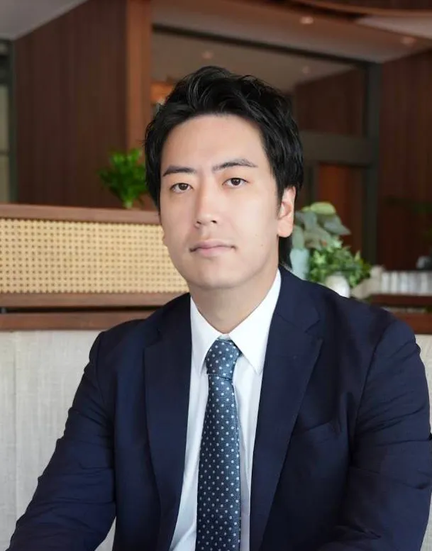 厳格な面持ちで正面見ている長谷川陽介先生の写真。